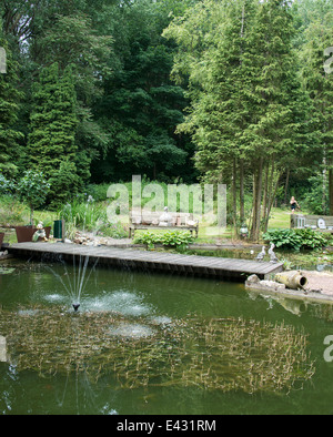 Jardin anglais avec pont de l'eau de l'étang et de vases anciens Banque D'Images