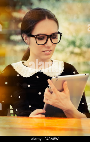 Jeune femme avec des lunettes et tablette Banque D'Images