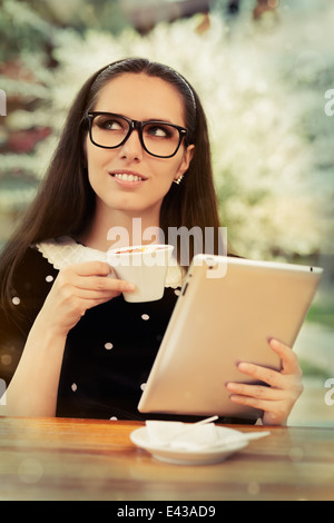 Jeune femme avec des lunettes et tablette Le Café Banque D'Images