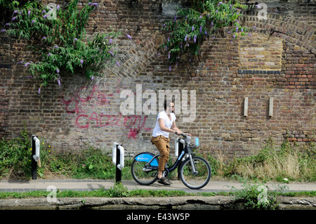 Cyclistes masculins sur Barclays Cycle ou Boris Bike Négocier une chicane installés sur le Regent's Canal de halage pour ralentir les cyclistes Banque D'Images