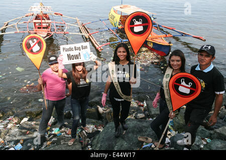 Manille, Philippines. 3 juillet, 2014. La princesse Manzon, Miss Earth Foundation, Inc. Directeur exécutif, Miss Philippines Air Terre 2014 Diane Querrer, et Miss Philippines Terre Bencelle Bianzon runner up avec d'autres bénévoles sont le long de la montée des ordures de la baie de Manille de la banque comme ils protestent pour l'interdiction totale des sacs en plastique. Les bénévoles montrent par Earth Island Institute des Philippines et Miss Earth Foundation a organisé une journée de nettoyage en commémoration de l'International Plastic Bag- journée libre à Manille. Crédit : J Gerard Seguia/Pacific Press/Alamy Live News Banque D'Images