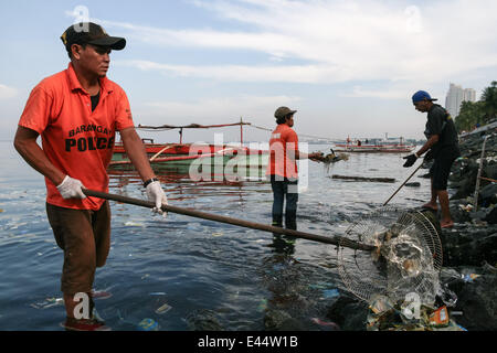 Manille, Philippines. 3 juillet, 2014. Un bénévole utilise un outil de fortune, d'un ventilateur électrique, qu'il participe avec d'autres bénévoles pendant l'Aucun sac en plastique journée de nettoyage à la baie de Manille à Roxas Boulevard à Manille. Les bénévoles montrent par Earth Island Institute des Philippines et Miss Earth Foundation a organisé une journée de nettoyage en commémoration de l'International Plastic Bag- journée libre à Manille. Crédit : J Gerard Seguia/Pacific Press/Alamy Live News Banque D'Images