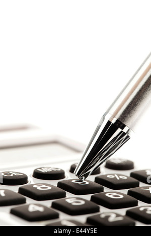 Une calculatrice et un stylo lors du calcul du bilan, les revenus et les bénéfices.