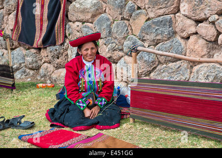 Femme âgée portant un chapeau, en vêtements traditionnels indiens Quechua, assis sur le sol en face de la civière d'un métier Banque D'Images