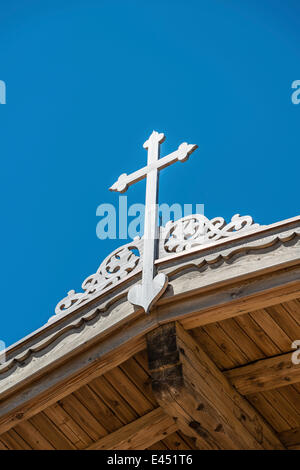 Crucifix sur un toit de bois contre un ciel bleu Banque D'Images