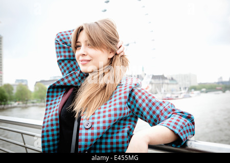 Young Woman leaning against garde-corps sur la passerelle du Jubilé, London, UK Banque D'Images