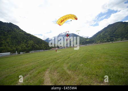 Équipe de trois parachutistes dans la zone d'atterrissage avec des parachutes, Interlaken, Berne, Suisse Banque D'Images