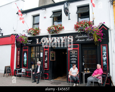 Les personnes qui boivent une bière en face d'un pub irlandais à Clifden, Irlande Banque D'Images