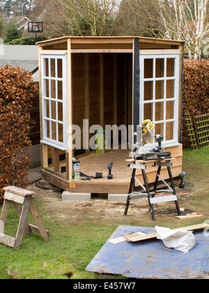 La construction de soi, la construction d'abri abri de jardin, avec cadre en bois de chêne et de grandes fenêtres rondes conseil en plumes Banque D'Images