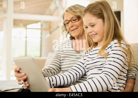 Grand-mère et petite-fille using digital tablet Banque D'Images