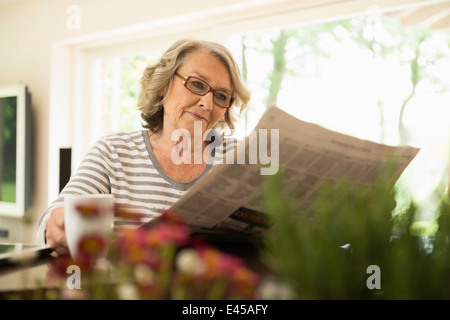 Le Senior woman reading newspaper Banque D'Images