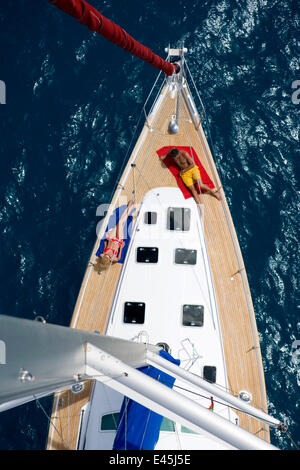 Vue depuis la tête de mât d'un couple de détente sur la plage avant d'un Sunsail Oceanis 423 dans les IVB, mars 2006. Propriété et modèle publié. Banque D'Images