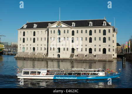 National Maritime Museum, Het Scheepvaartmuseum, Amsterdam Pays-Bas avec bateau de tourisme passant Banque D'Images