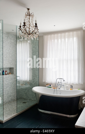 Salle de bains contemporaine avec lustre en cristal et baignoire sur pieds Banque D'Images