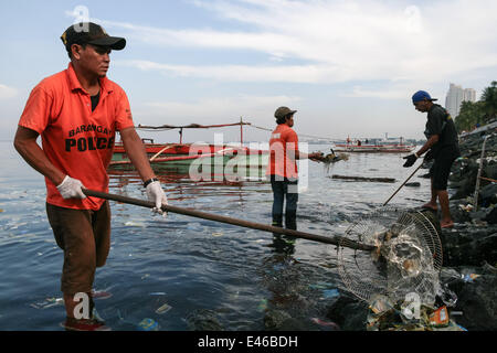 Manille, Philippines. 3 juillet, 2014. Un bénévole utilise un outil de fortune, d'un ventilateur électrique, qu'il participe avec d'autres bénévoles pendant l'Aucun sac en plastique journée de nettoyage à la baie de Manille à Roxas Boulevard à Manille. Les bénévoles montrent par Earth Island Institute des Philippines et Miss Earth Foundation a organisé une journée de nettoyage en commémoration de l'International Plastic Bag- journée libre à Manille. Crédit : J Gerard/NurPhoto Seguia/ZUMA/Alamy Fil Live News Banque D'Images