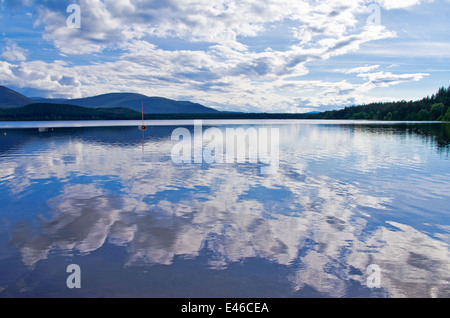 Ciel bleu et nuages blancs reflétés dans le Loch Morlich, soir d'été, près d'Aviemore, Parc National de Cairngorms, en Écosse, Royaume-Uni Banque D'Images