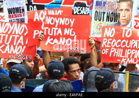 Manille, Philippines. 4 juillet, 2014. Maintenez les militants des pancartes lors d'un meeting de protestation à Manille, Philippines, le 4 juillet 2014. Les militants ont marqué la 68e Journée de l'amitié américano-Philippine avec un meeting de protestation à demander la redirection de l'Accord de coopération de défense entre les États-Unis et les Philippines. Source : Xinhua/Alamy Live News Banque D'Images