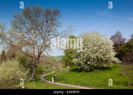 UK, Derbyshire, Peak District, Bakewell, couple en train de marcher le long du chemin de la rivière au printemps Banque D'Images