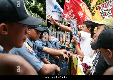 Manille, Philippines. 4 juillet, 2014. Anakbayan Président The Crisostomo montre à la police sa main après leur altercation lors de la lutte contre les Etats-Unis le long de Kalaw Avenue à Manille. © J Gerard NurPhoto Seguia/ZUMA/wire/Alamy Live News Banque D'Images