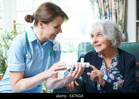 Infirmière Conseiller senior Woman sur le médicament à la maison Banque D'Images