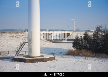 Fondation d'un grand moulin près d'une autoroute dans un paysage enneigé des Pays-Bas Banque D'Images