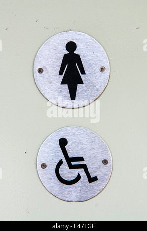 Les panneaux pour un mesdames et toilettes pour handicapés sur une porte Banque D'Images