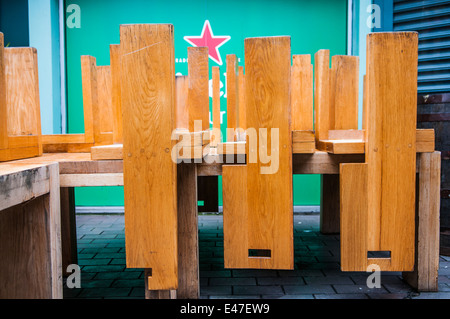 Chaises en bois empilées à l'envers sur les tables à l'extérieur d'un pub. Banque D'Images