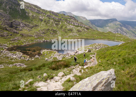 Les marcheurs sur le chemin de Bwlch à Bochlwyd Tryfan Llyn glaciaire en vallée suspendue dans les montagnes de Snowdonia au nord du Pays de Galles Royaume-uni Grande-Bretagne Banque D'Images