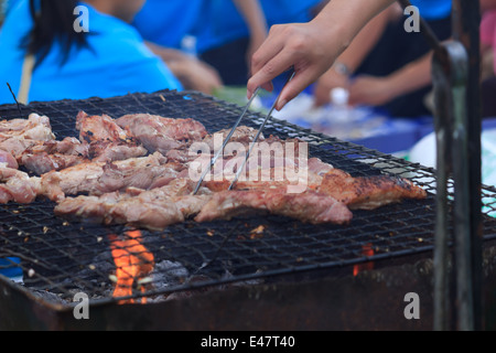 Les gens sont de porc cuisson sur la cuisinière Banque D'Images