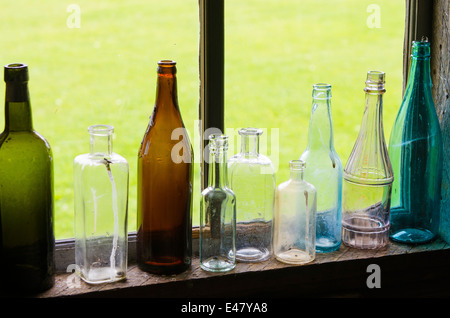 Bouteilles en verre antique dans la fenêtre de cabine à la Heritage Park Museum, Terrace, Colombie-Britannique, Canada. Banque D'Images