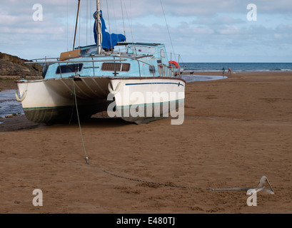 Yacht avec son ancre à marée basse sur la plage, Bude, Cornwall, UK Banque D'Images