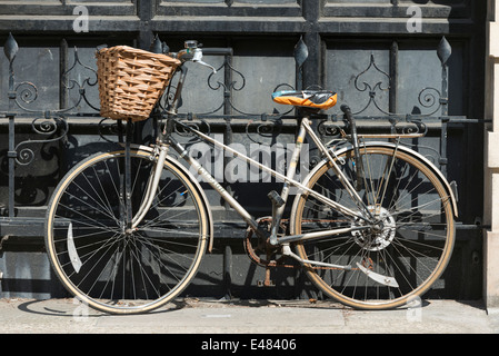 Un vélo traditionnel avec panier appuyé contre un mur Banque D'Images