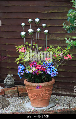 Sphères métalliques décoratifs en terre cuite dans un pot de fleurs, plantes jardin environnement. Banque D'Images