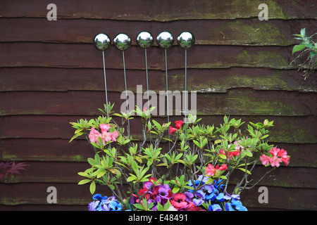 Sphères métalliques décoratifs en terre cuite dans un pot de fleurs, plantes jardin environnement. Banque D'Images