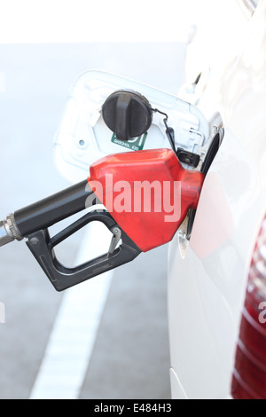 Le pistolet rouge à verser à voiture sur station d'essence. Banque D'Images