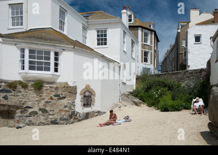 Un homme et les femmes vous détendre sur un joli coin de St Ives Harbour Beach à Cornwall Banque D'Images