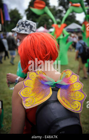 Great Tew, l'Oxfordshire. 5 juillet 2014. Cornbury Festival de musique. Jeune femme portant une perruque rouge et les ailes de papillon à Cornbury Music Festival, Oxforshire. Banque D'Images