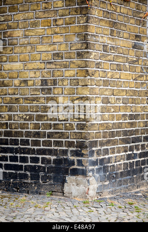 Bord d'un vieux mur de briques avec trottoir pour les fonds. Banque D'Images
