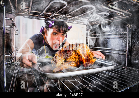 Ménagère prépare le poulet rôti au four, vue de l'intérieur du four. La cuisson au four. Banque D'Images