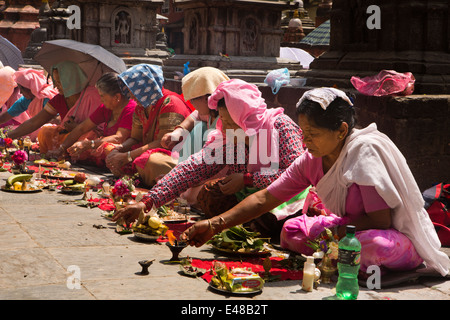 Le Népal, Katmandou, Stupa Kathesimbhu,entreprise de femmes tibétaines bouddhistes rituel puja lampe d'éclairage Banque D'Images