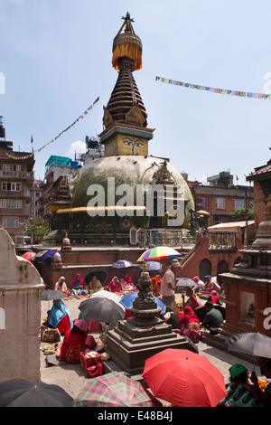 Le Népal, Katmandou, Stupa Kathesimbhu,femme tibétaine rituel puja bouddhiste entreprise sous les parasols Banque D'Images