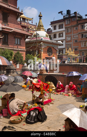 Le Népal, Katmandou, Stupa Kathesimbhu,femme tibétaine rituel puja bouddhiste entreprise sous les parasols Banque D'Images