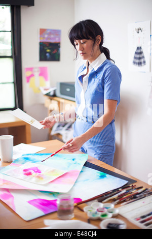 Femme travaillant dans son atelier de peinture Banque D'Images