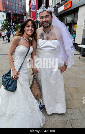 Derry, Londonderry, Irlande du Nord, Royaume-Uni - 05 juillet 2014. Recueillir des épouses pour tentative de record du monde. Brendan Kelly (à droite) et sa sœur Caroline Young ont été parmi les centaines de jeunes mariées qui ont traversé le pont de la paix, Derry, dans une tentative de créer un nouveau record mondial pour le nombre d'épouses se sont réunis en un seul endroit. 748 l'année dernière, y compris les épouses de quelques hommes, traversé le pont de la paix pour gagner une place dans le Guinness Book des Records. Crédit : George Sweeney / Alamy Live News Banque D'Images