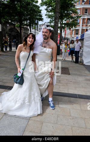 Derry, Londonderry, Irlande du Nord, Royaume-Uni - 05 juillet 2014. Recueillir des épouses pour tentative de record du monde. Brendan Kelly (à droite) et sa sœur Caroline Young ont été parmi les centaines de jeunes mariées qui ont traversé le pont de la paix, Derry, dans une tentative de créer un nouveau record mondial pour le nombre d'épouses se sont réunis en un seul endroit. 748 l'année dernière, y compris les épouses de quelques hommes, traversé le pont de la paix pour gagner une place dans le Guinness Book des Records. Crédit : George Sweeney / Alamy Live News Banque D'Images