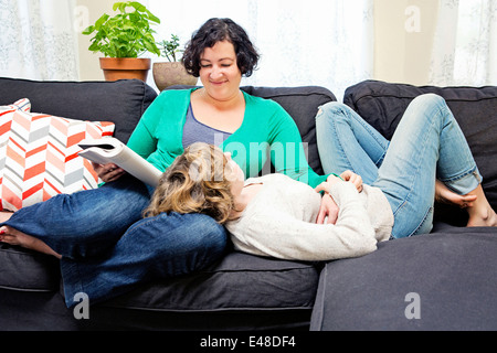 Femme couple lying on sofa Banque D'Images