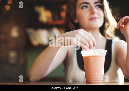Jeune femme à boire smoothie Banque D'Images