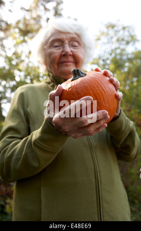 Low angle view of senior woman holding pumpkin Banque D'Images