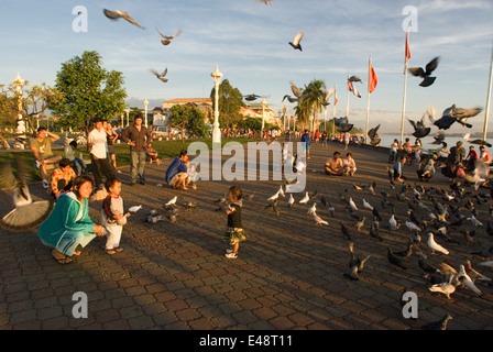 Mère et fille se nourrir les pigeons près du lac Tonlé Sap. Phnom Penh. Peuple Khmer sont le groupe ethnique dominant au Cambodge Banque D'Images