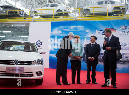 La chancelière allemande Angela Merkel (2L), Martin Winterkorn (L), président du conseil d'administration de Volkswagen AG, Xu Jianyi (3L), le président de la First Automotive Works, et Jochem Heizmann (R), membre du conseil de Volkswagen AG, parler à l'autre pendant leur visite à la FAW-VW usine de production à Shenzhen, Chine. 6 juillet 2014. Angela Merkel est accompagné d'une délégation commerciale de haut niveau et va rester en Chine avant le 08 juillet 2014. Merkel est également prévu de visiter Beijing pendant son voyage. Photo : Kay Nietfeld/dpa Banque D'Images